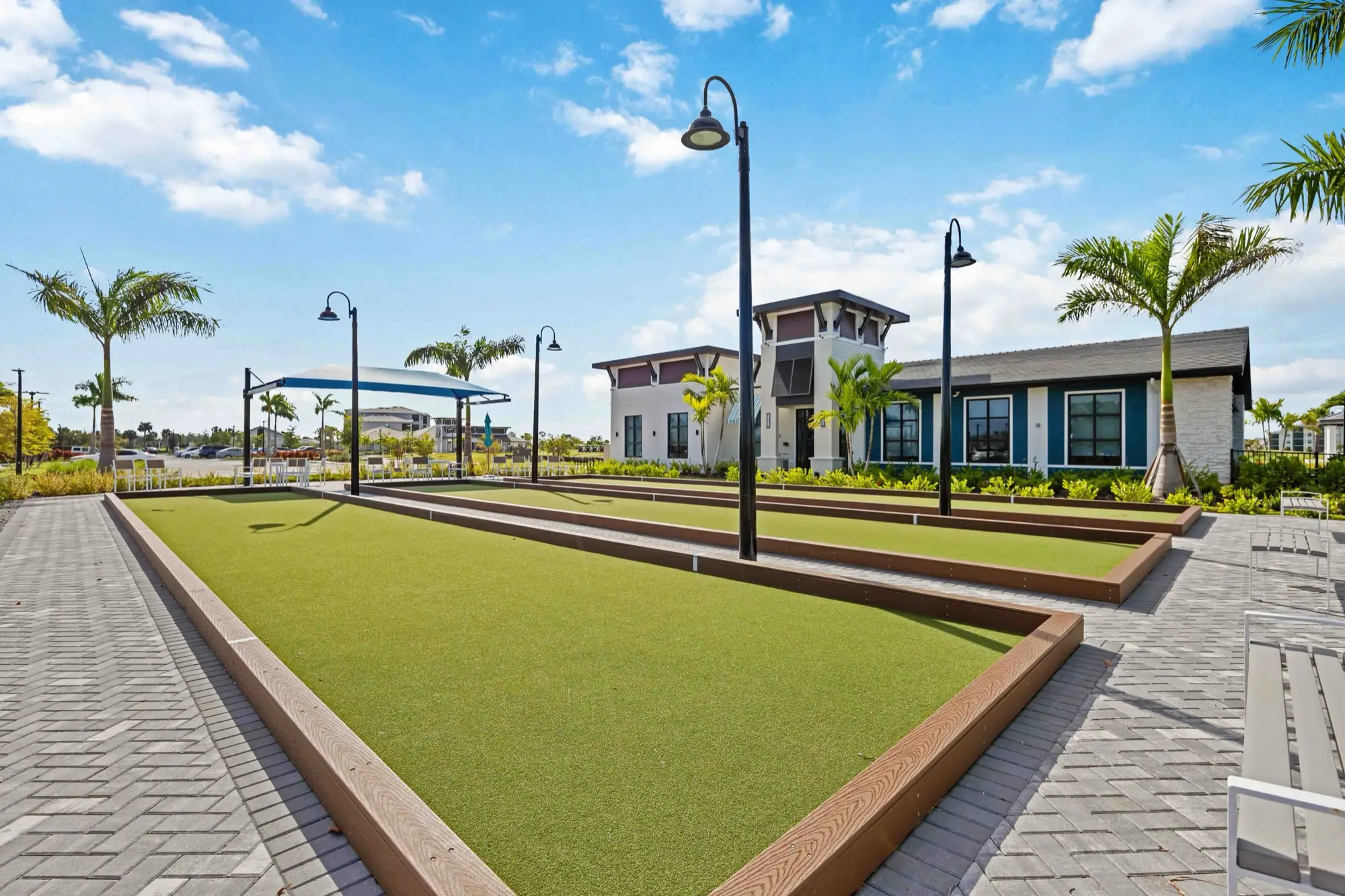 Three bocce ball courts with shade lighting in front of the clubhouse at Wellen Park Golf & Country Club